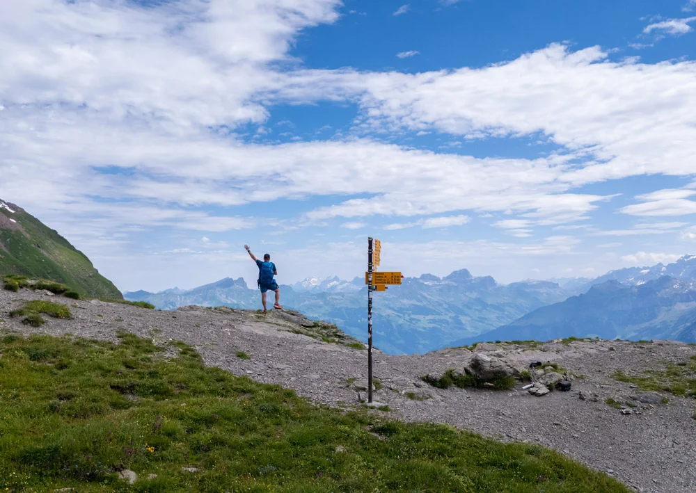 Caminhante em um passo alpino diante das montanhas