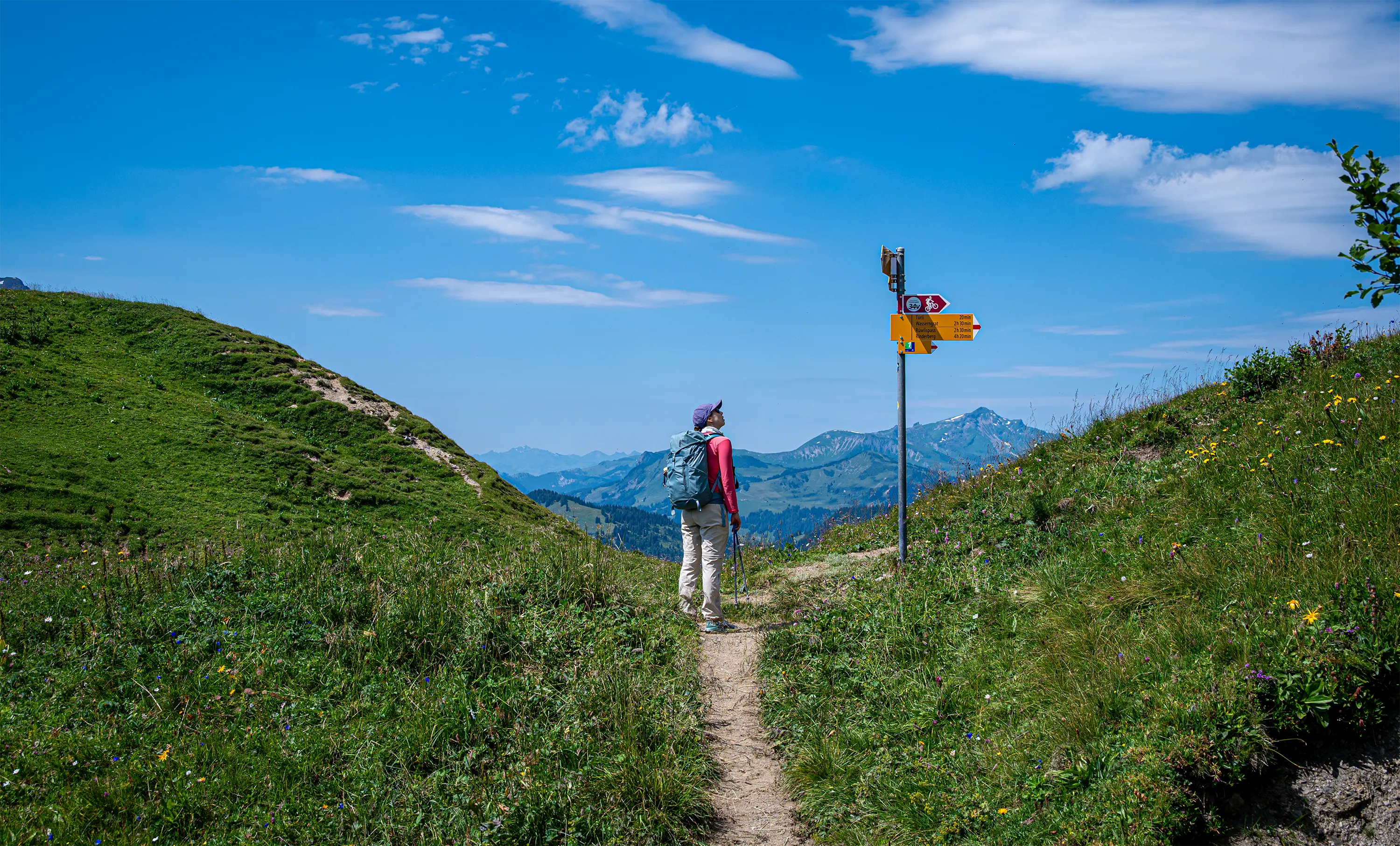 Placas amarelas orientam a caminhada entre as encostas dos Alpes suíços.
